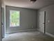 Bright bedroom features a window that lets in natural light and neutral walls at 6841 Phillips Mill Rd, Douglasville, GA 30135