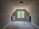 This cozy bedroom has charmingly angled ceilings and a bright window view at 6841 Phillips Mill Rd, Douglasville, GA 30135