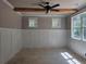 A well lit bedroom features wainscotting detail, windows and ceiling fan at 6841 Phillips Mill Rd, Douglasville, GA 30135