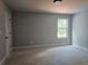 An inviting bedroom features neutral walls and a window bringing the outdoors in at 6841 Phillips Mill Rd, Douglasville, GA 30135