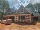 New home's exterior with a covered front porch featuring gray siding, contrasting trim, and a well-designed roof at 6841 Phillips Mill Rd, Douglasville, GA 30135