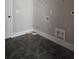 A laundry room with new dark tile flooring and hookups in place for washer/dryer at 6841 Phillips Mill Rd, Douglasville, GA 30135