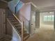 Staircase featuring dark iron balusters, wood handrail, leading to an open living area with natural light at 6841 Phillips Mill Rd, Douglasville, GA 30135