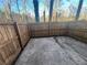 Fenced backyard area with a concrete patio and views of trees in a wooded area at 7042 Oakhill Cir, Austell, GA 30168