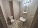 Small bathroom featuring a toilet, pedestal sink, patterned floor, and vanity mirror with overhead lighting at 7042 Oakhill Cir, Austell, GA 30168