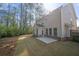 View of backyard, showcasing a well-maintained lawn, a patio, and natural surroundings with trees and sunlight at 830 Nottingham Se Dr, Smyrna, GA 30082
