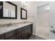 Bathroom featuring double vanity with granite countertops and dark wood cabinets at 830 Nottingham Se Dr, Smyrna, GA 30082