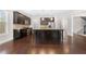 Modern kitchen with dark wood cabinets, stainless steel appliances, granite countertops, and an open layout adjacent to the stairs at 830 Nottingham Se Dr, Smyrna, GA 30082