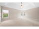 Spacious main bedroom featuring neutral decor, tray ceiling with fan, and carpeted floor at 830 Nottingham Se Dr, Smyrna, GA 30082