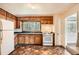 Cozy kitchen featuring wooden cabinets, a window overlooking the yard, and a white refrigerator and stove at 195 Hermer Nw Cir, Atlanta, GA 30311