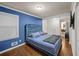 Blue accent wall, plush headboard, hardwood floor, and natural light creates a relaxing primary bedroom at 3021 San Juan Dr, Decatur, GA 30032