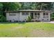 Charming one-story home with gray brick, updated windows, manicured lawn, and mature trees at 3021 San Juan Dr, Decatur, GA 30032