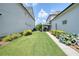 Well-manicured backyard featuring green lawn, flower beds, and covered patio area between two light colored homes at 4105 Brookview Dr, Cumming, GA 30040
