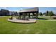 Shaded pergola with stone picnic table and chairs on a well-manicured lawn at 4105 Brookview Dr, Cumming, GA 30040