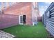 Enclosed backyard with artificial turf, brick walls, and a door leading to the interior space at 490 Marietta Nw St # 101, Atlanta, GA 30313
