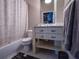 Well-lit bathroom featuring a tiled floor, gray vanity, and a shower-tub combination with a patterned shower curtain at 490 Marietta Nw St # 101, Atlanta, GA 30313