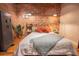 Comfortable bedroom with exposed brick wall and modern industrial design elements and light-colored bedspread at 490 Marietta Nw St # 101, Atlanta, GA 30313