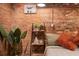 Exposed brick accent wall, plant, and floating shelves add charm to this stylish apartment bedroom at 490 Marietta Nw St # 101, Atlanta, GA 30313