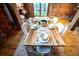 Elegant dining room featuring a wooden table and modern upholstered chairs, exposed brick, and natural light at 490 Marietta Nw St # 101, Atlanta, GA 30313