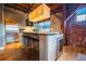 Modern kitchen with stainless steel appliances, island with seating, and exposed brick accents at 490 Marietta Nw St # 101, Atlanta, GA 30313