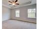 Spacious bedroom featuring a ceiling fan, tray ceiling, and natural light from the two windows at 3135 Washburn St, Atlanta, GA 30354