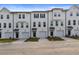 New townhomes with white exteriors, black trim, garages, and small landscaped yards at 3135 Washburn St, Atlanta, GA 30354