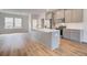 Modern kitchen with grey cabinets, stainless appliances, island, and wood-look vinyl flooring at 3135 Washburn St, Atlanta, GA 30354