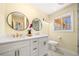 Updated bathroom features dual sinks, a marble countertop and round mirrors at 4562 Anderson Livsey Ln, Snellville, GA 30039