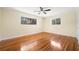 Sunlit bedroom features hardwood floors, a ceiling fan and two picture windows at 4562 Anderson Livsey Ln, Snellville, GA 30039