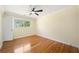 Cozy bedroom featuring a large window, ceiling fan and hardwood floors at 4562 Anderson Livsey Ln, Snellville, GA 30039