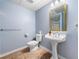 Powder room with a pedestal sink, soft blue walls, and tiled floors at 5071 Vinings Estates Se Ct, Mableton, GA 30126