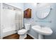 This bathroom features a shower-tub combo and a single sink with wood-look floors at 5071 Vinings Estates Se Ct, Mableton, GA 30126