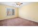 Cozy carpeted bedroom with a ceiling fan and large window offering plenty of natural light at 5071 Vinings Estates Se Ct, Mableton, GA 30126