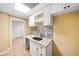 Wet bar with granite countertop, tile backsplash, stainless steel sink, and white cabinets at 5071 Vinings Estates Se Ct, Mableton, GA 30126