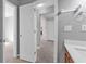 Hallway view of bathroom with wood vanity and white quartz countertop at 1358 Mckinsey Rdg, Loganville, GA 30052