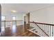 Second-floor hallway with wood floors, staircase with rod iron spindles and access to rooms at 3483 Summerlin Pkwy, Lithia Springs, GA 30122
