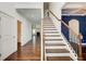 Open staircase with wood and iron railing leading to upstairs, wood floors at 3483 Summerlin Pkwy, Lithia Springs, GA 30122