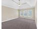 Expansive bedroom with plush carpet, tray ceiling, and abundant natural light through shuttered windows at 2021 Cockrell Pointe Nw, Kennesaw, GA 30152