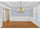 Elegant dining room featuring hardwood floors, wainscoting, and a stylish chandelier at 2021 Cockrell Pointe Nw, Kennesaw, GA 30152