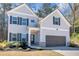 Charming two-story home with a two car garage, dark shutters, and neatly landscaped front yard at 2099 Easterwood Ter, Decatur, GA 30032
