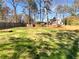 Large, grassy backyard is surrounded by mature trees and a wooden fence at 2111 Cedar Forks Dr, Marietta, GA 30062