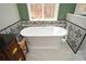 Elegant bathroom features a soaking tub with decorative tile surround and a large window with a scenic view at 120 Mill Creek Ct, Acworth, GA 30101