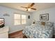 Comfortable bedroom features a ceiling fan, hardwood floors, and a sunlit window at 120 Mill Creek Ct, Acworth, GA 30101