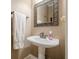 Charming powder room featuring a pedestal sink, decorative mirror, and neutral tones at 1765 Dew Pl, Marietta, GA 30064