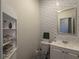 Stylish powder room featuring a decorative tile accent wall, vanity and fixtures at 3469 English Elm Way, Loganville, GA 30052
