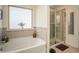 Bright bathroom featuring a soaking tub, tiled shower, and neutral decor at 3469 English Elm Way, Loganville, GA 30052