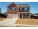 Two-story brick home with a two-car garage and a well-manicured front yard, offering classic curb appeal at 3469 English Elm Way, Loganville, GA 30052