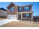 Brick-front two-story home with a two-car garage and charming landscaping offers an inviting and well-maintained exterior at 3469 English Elm Way, Loganville, GA 30052