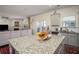Open kitchen with granite countertops and center island connects seamlessly to the cozy living room at 3469 English Elm Way, Loganville, GA 30052