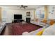 Comfortable living room with a decorative rug, ceiling fan, fireplace and cozy sectional sofa with yellow throw pillows at 3469 English Elm Way, Loganville, GA 30052